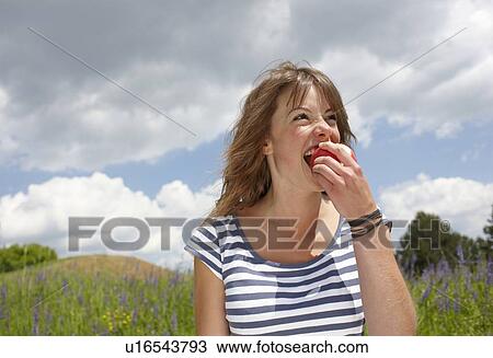 Woman eating apple outdoors View Large Photo Image Stock Image - Woman eating apple outdoors. Fotosearch
