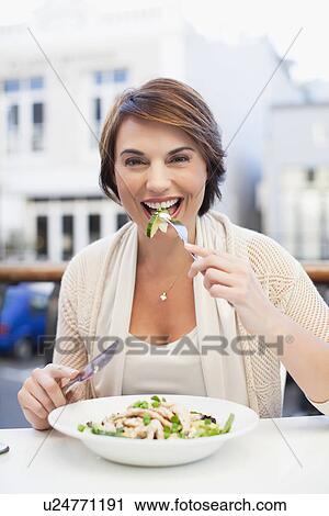 Woman eating at sidewalk cafe View Large Photo Image Stock Image - Woman eating at sidewalk cafe. Fotosearch