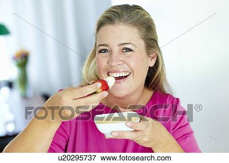 Woman eating strawberry and cream View Large Photo Image Stock Photo - Woman eating strawberry and cream. Fotosearch