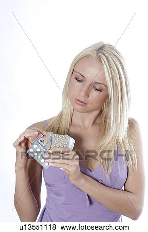 Woman examining blister packs of pills View Large Photo Image Stock Photo - Woman examining blister packs of pills. Fotosearch