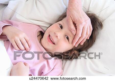 Woman feeling girls forehead View Large Photo Image Stock Image - Woman feeling girls forehead. Fotosearch