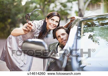 Woman giving directions to man in car View Large Photo Image Stock Image - Woman giving directions to man in car. Fotosearch