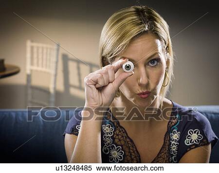 Woman holding glass eye in living room View Large Photo Image Stock Photography - Woman holding glass eye in living room. Fotosearch