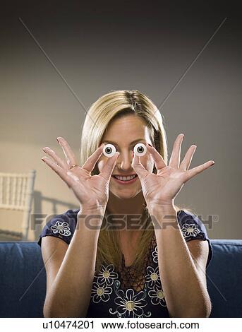 Woman holding glass eyes in living room View Large Photo Image Stock Image - Woman holding glass eyes in living room. Fotosearch