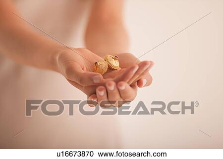Woman holding golden ornaments View Large Photo Image Stock Image - Woman holding golden ornaments. Fotosearch