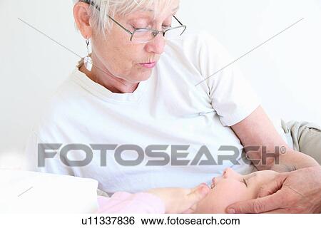 Woman holding granddaughter in bed View Large Photo Image Stock Photograph - Woman holding granddaughter in bed. Fotosearch