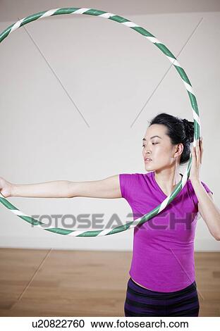 Woman holding hula hoop indoors View Large Photo Image Stock Image - Woman holding hula hoop indoors. Fotosearch