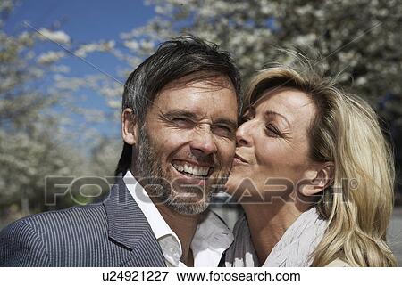 Woman kissing boyfriend outdoors View Large Photo Image Stock Photo - Woman kissing boyfriend outdoors. Fotosearch