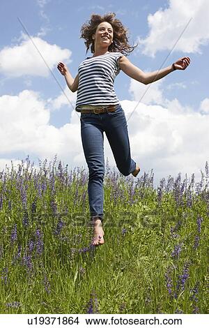 Woman leaping in tall grass View Large Photo Image Picture - Woman leaping in tall grass. Fotosearch