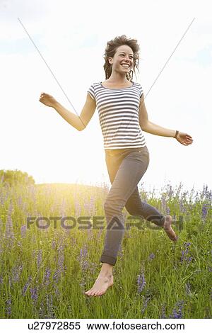 Woman leaping in tall grass View Large Photo Image Stock Photography - Woman leaping in tall grass. Fotosearch