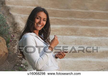 Woman listening to headphones outdoors View Large Photo Image Stock Photo - Woman listening to headphones outdoors. Fotosearch