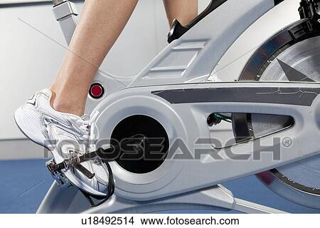Woman pedaling stationery bicycle View Large Photo Image Picture - Woman pedaling stationery bicycle. Fotosearch