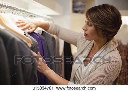 Stock Image - Woman picking out clothes. Fotosearch