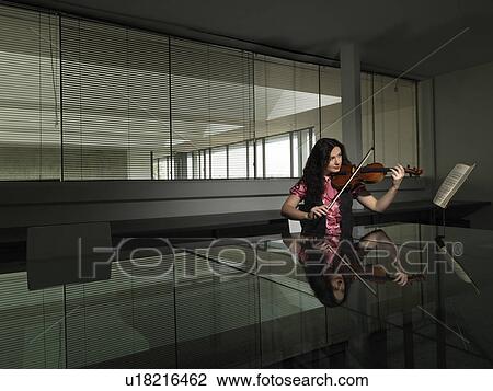 Stock Image - Woman playing violin in business office. Fotosearch