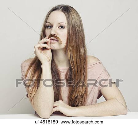 Stock Photo - Woman playing with hair as mustache. Fotosearch