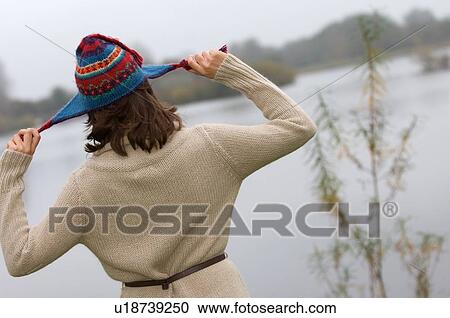 Stock Image - Woman playing with knitted hat outdoors. Fotosearch