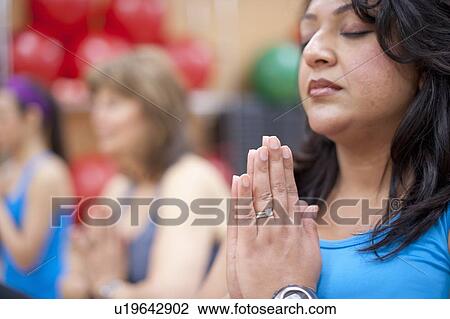 Stock Image - Woman practicing yoga in studio. Fotosearch
