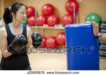 Stock Photograph - Woman punching bag in gym. Fotosearch