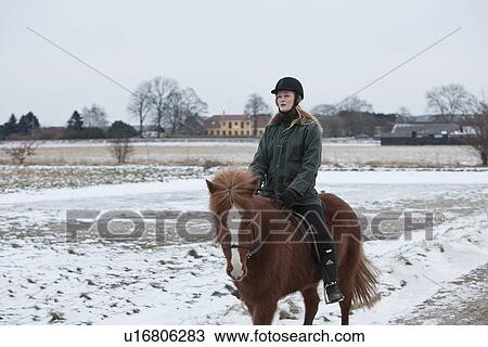 Woman riding horse on snowy path View Large Photo Image Stock Image - Woman riding horse on snowy path. Fotosearch