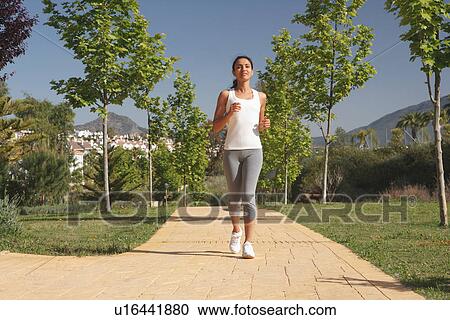 Stock Image - Woman running in park. Fotosearch