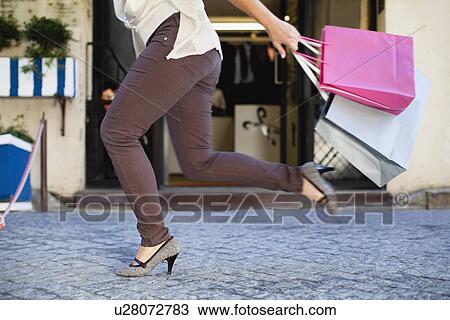 Woman running with shopping bags View Large Photo Image Stock Image - Woman running with shopping bags. Fotosearch