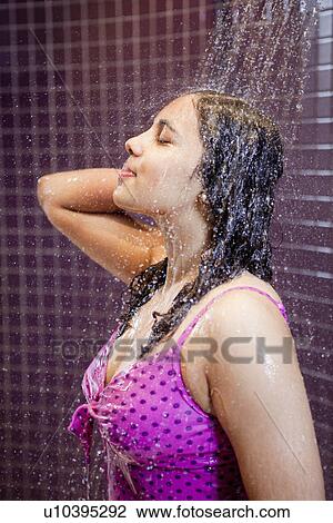 Stock Image - Woman showering in swimsuit. Fotosearch