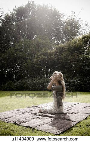 Woman sitting on blanket in park View Large Photo Image Stock Photo - Woman sitting on blanket in park. Fotosearch