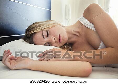 Stock Image - Woman sleeping in bed. Fotosearch