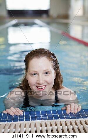 Stock Image - Woman smiling in indoor pool. Fotosearch