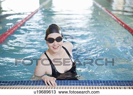 Woman smiling in indoor pool View Large Photo Image Stock Image - Woman smiling in indoor pool. Fotosearch