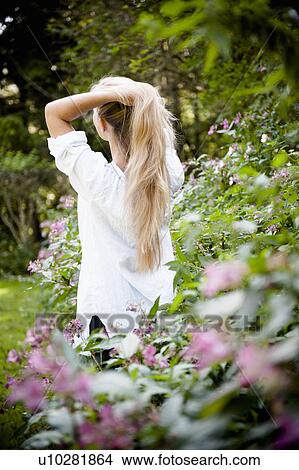 Woman standing in flower bushes View Large Photo Image Picture - Woman standing in flower bushes. Fotosearch