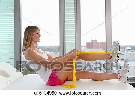 Woman stretching in doctors office View Large Photo Image Stock Image - Woman stretching in doctors office. Fotosearch