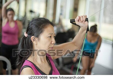 Stock Photo - Woman stretching in gym. Fotosearch