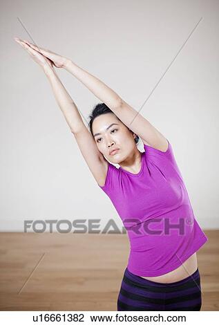Stock Image - Woman stretching indoors. Fotosearch