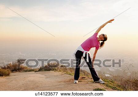 Woman stretching on hilltop View Large Photo Image Stock Photo - Woman stretching on hilltop. Fotosearch