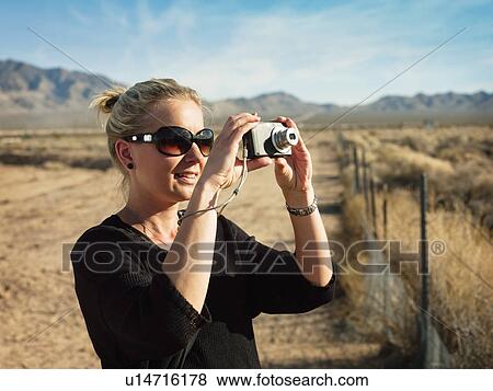 Woman taking pictures, on the road from Los Angeles to Las Vegas View Large Photo Image Stock Photo - Woman taking pictures, on the road from Los Angeles to Las Vegas. Fotosearch