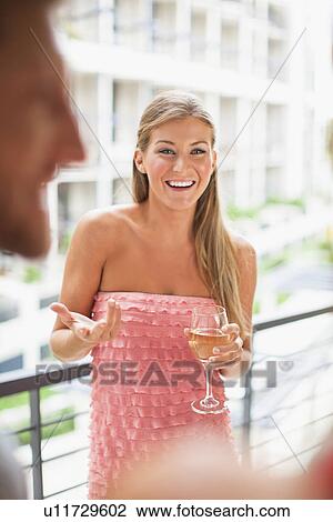 Stock Image - Woman talking in group at party. Fotosearch