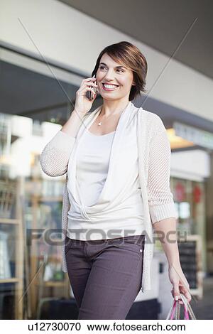 Woman talking on cell phone on street View Large Photo Image Stock Image - Woman talking on cell phone on street. Fotosearch