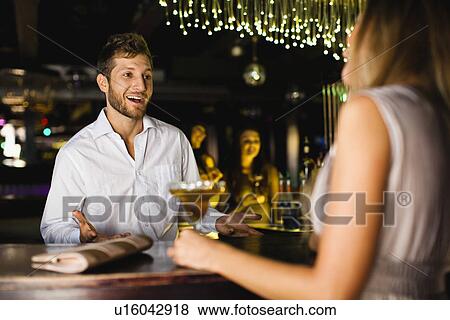 Woman talking to bartender at bar View Large Photo Image Stock Photo - Woman talking to bartender at bar. Fotosearch