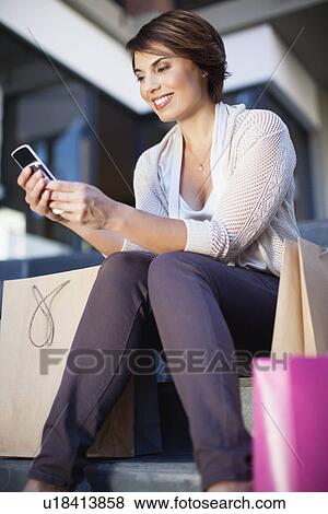 Woman using cell phone on city street View Large Photo Image Stock Photo - Woman using cell phone on city street. Fotosearch