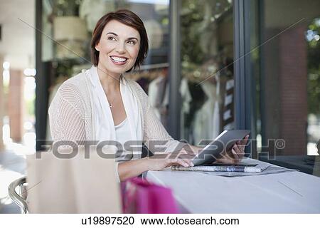Woman using tablet computer in cafe View Large Photo Image Stock Image - Woman using tablet computer in cafe. Fotosearch