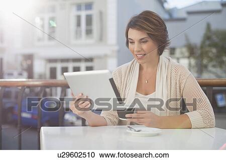 Woman using tablet computer in cafe View Large Photo Image Stock Image - Woman using tablet computer in cafe. Fotosearch