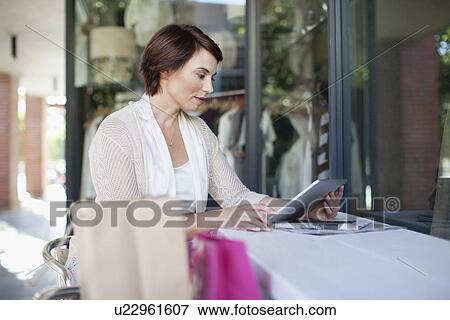 Woman using tablet computer in cafe View Large Photo Image Stock Photo - Woman using tablet computer in cafe. Fotosearch