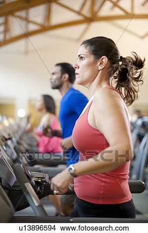 Woman using treadmill in gym View Large Photo Image Picture - Woman using treadmill in gym. Fotosearch