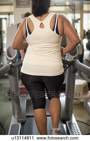 Woman using treadmill in gym View Large Photo Image Stock Image - Woman using treadmill in gym. Fotosearch