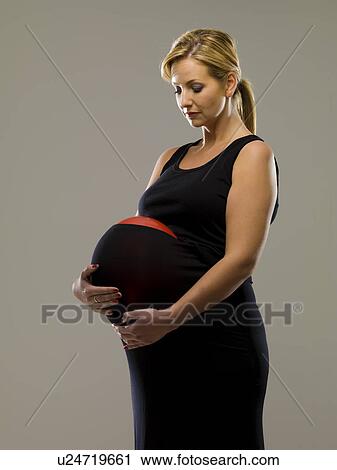Stock Image - Woman wearing balloon inside skirt. Fotosearch