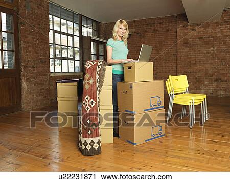 Woman with cardboard boxes in new home View Large Photo Image Stock Image - Woman with cardboard boxes in new home. Fotosearch
