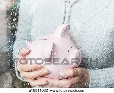 Woman with piggy bank at rainy window View Large Photo Image Stock Image - Woman with piggy bank at rainy window. Fotosearch