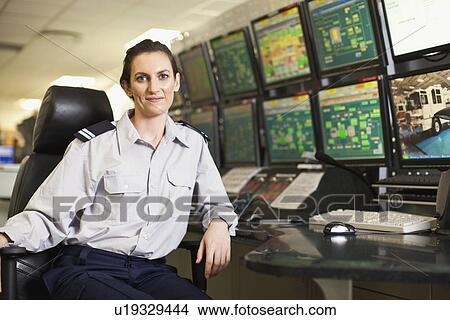 Picture - Woman working in security control room. Fotosearch