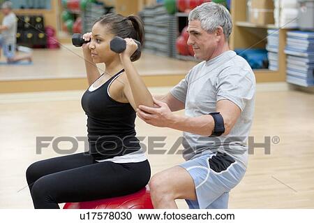 Woman working with trainer in gym View Large Photo Image Stock Image - Woman working with trainer in gym. Fotosearch